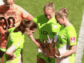 three female soccer players wearing green jerseys with id.3 on them