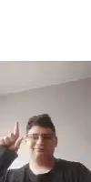 a young man wearing glasses and a black shirt giving the middle finger