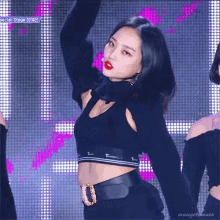 a woman in a black crop top stands in front of a screen with the words special stage on it
