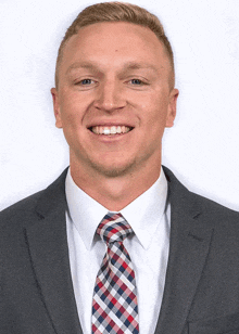a man in a suit and tie smiles for a picture