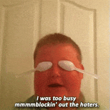 a man wearing plastic spoons on his eyes says " i was too busy mmmmmblockin ' out the haters "