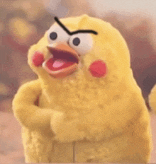 a stuffed yellow chicken with red cheeks and a black eye is looking angry .