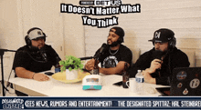 three men are sitting at a table with microphones and a sign that says it doesn 't matter what you think