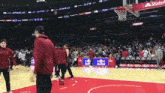 a basketball game is being played in a stadium with a kia banner in the background