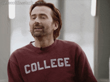 a man wearing a maroon sweatshirt that says college on it
