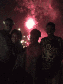 a group of people are posing for a picture in front of fireworks