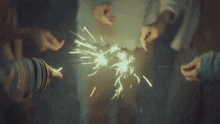 a group of people holding sparklers in their hands in the dark