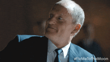 a man in a suit and tie with #flymetothemoon written on the bottom