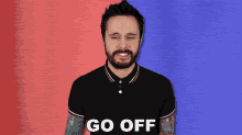 a man with a beard wearing a black polo shirt says go off