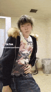 a person wearing a fur hooded jacket and a t-shirt with a picture of a woman on it