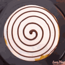 a chocolate swirl on a white cake with easy plus written on the bottom right