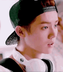 a young man wearing a hat and headphones is looking at something .
