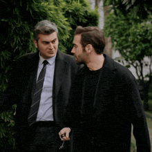 a man in a suit and tie is talking to another man