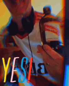 a person holding a bottle of alcohol with the word yes written on it