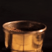 a cup of coffee is being poured into a strainer
