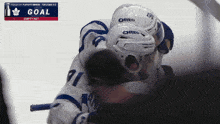 a hockey player wearing an oreo helmet hugging another player