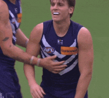 a man in a blue tank top with the letters ns on it