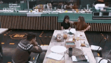 a group of people sitting at a table with a sign that says diario