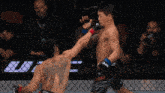 a man with a tattoo on his back is fighting another man in a cage