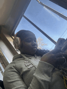 a girl wearing headphones and a hoodie that says abercrombie