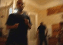 a blurry picture of a man in a black shirt standing in a room