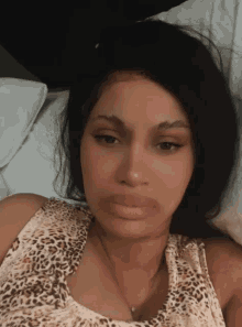 a woman in a leopard print tank top is laying down