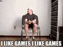 a man is sitting in a chair playing a video game with the words " i like games i like games " above him