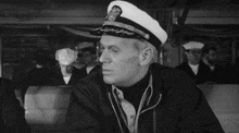 a man in a military uniform is smoking a cigarette while sitting on a couch .