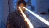 a man 's eyes are glowing with a beam of light coming out of them
