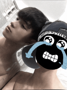 a boy with a cartoon face on his face is looking at his reflection in a mirror