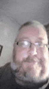 a man with a beard wearing glasses and a black shirt