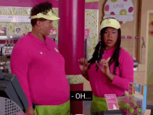 a woman in a pink shirt is talking to another woman who is wearing a yellow hat with the word chill on it