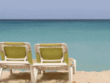 a couple of chairs on a beach looking out to the ocean