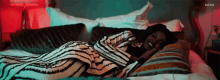 a woman is laying on a bed under a striped blanket with a blurred background that says blurvr