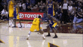 basketball players on a court in front of a toyota sign