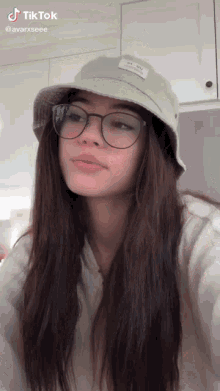 a girl wearing a bucket hat and glasses has a tiktok account