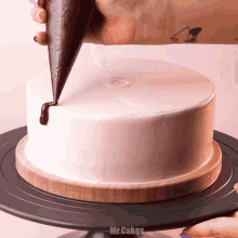 a cake is being decorated with chocolate and the words mr.cakes are visible