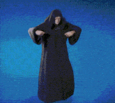 a man in a robe with a hood is standing on a blue background