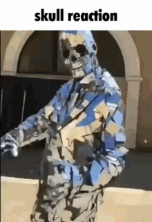 a man in a skeleton costume is standing in front of a building holding a gun .