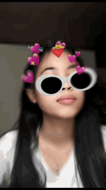 a girl wearing sunglasses with pink hearts on her forehead