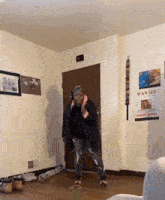 a woman is standing in a room with a wanted poster on the wall .