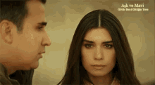 a man and a woman are looking at each other and the words aşk ve mavi are on the bottom