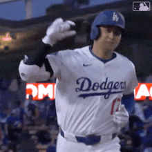 a baseball player wearing a dodgers jersey is giving a thumbs up