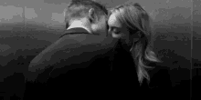 a man and woman are kissing in an elevator .