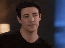 a close up of a man 's face wearing a black shirt and looking at the camera .