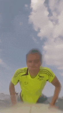 a person in a yellow shirt is running on a beach