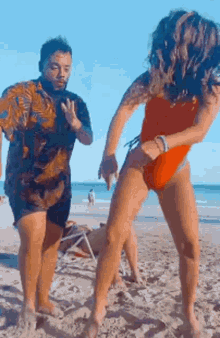a man and a woman are dancing on the beach