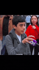 a boy talking into a microphone that says islamguzelligi