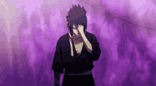 a man in a black kimono is standing in front of a purple background covering his face with his hand .