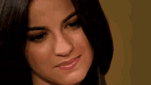 a close up of a woman 's face with a slight smile